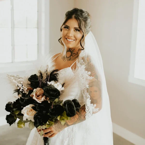 Smiling bride with half-up hair, long veil and black and blush bouquet, hair by Chair'istry Salon